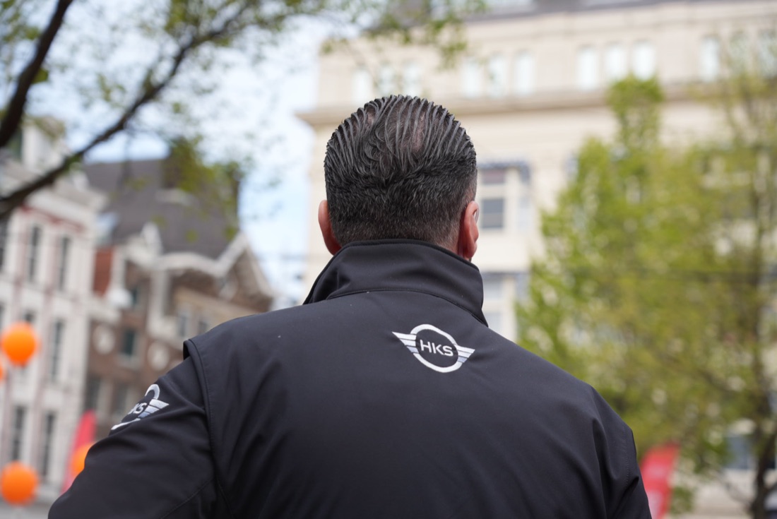 HKS-beveiliger van achteren met het HKS-embleem op zijn jas